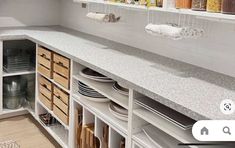 an image of a kitchen setting with dishes on the counter and plates in the cupboards