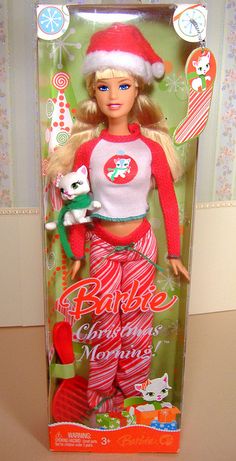 the barbie christmas doll is in its box and has a cat on her lap,