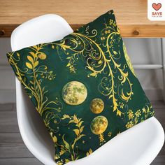 a green and yellow pillow sitting on top of a white chair next to a wooden table