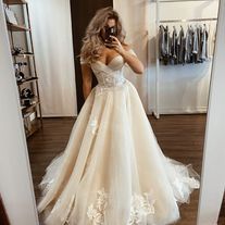 a woman taking a selfie in her wedding dress while looking at herself in the mirror