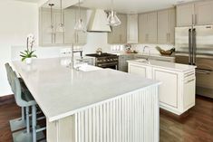 a large kitchen with an island and stainless steel appliances