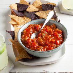 a bowl of salsa with tortilla chips on the side