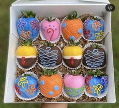 a box filled with lots of decorated cupcakes in the shape of animals and fruit