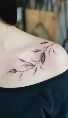 a woman with a tattoo on her shoulder has leaves growing out of the back of her shoulder