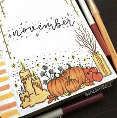 an open notebook with pumpkins and candles on it, next to two pencils