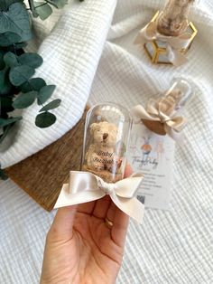 a person holding a small glass bottle with a teddy bear in it