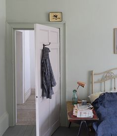 an open door leading to a bedroom with a bed and table in front of it