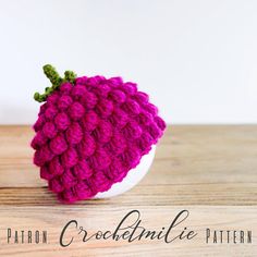 a crocheted hat sitting on top of a wooden table