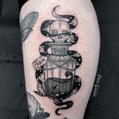 a tattoo on the leg of a person with a birdcage and skull in it