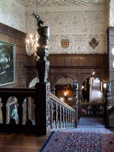 an ornately decorated staircase leads up to the second floor with chandeliers on either side