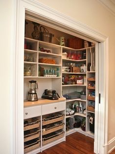 an open pantry with baskets and other items on the shelves in front of it,