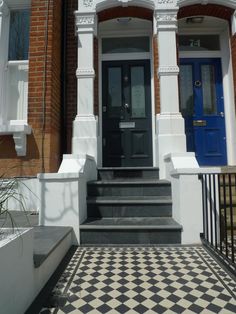 a black and white checkerboard floor in front of a building with blue door