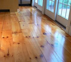 an empty room with wooden floors and windows