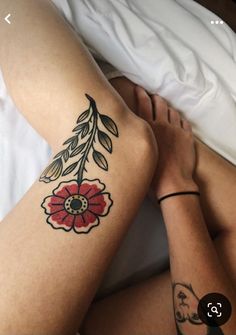 a woman laying in bed with a tattoo on her leg