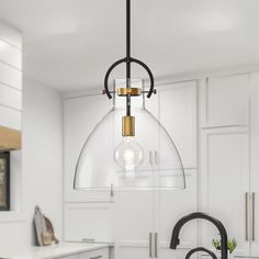 a kitchen with an island, sink and hanging glass dome light fixture in the center