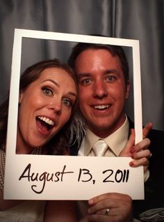 a man and woman holding up a sign that says august 13, 2011