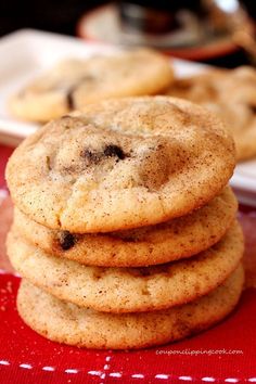 a stack of cookies sitting on top of a red cloth next to a white plate