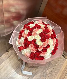 a bouquet of red and white roses on display