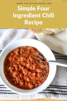 a white bowl filled with chili next to a plate of bread and a glass of milk