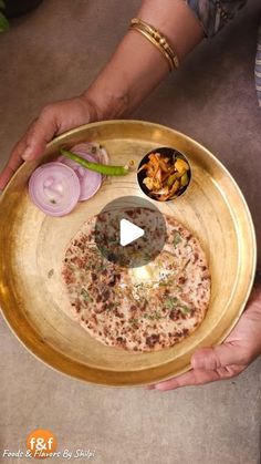 a person holding a platter with food on it and an onion dish in the middle