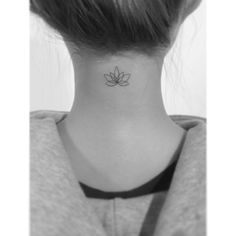 a woman's neck with a small lotus tattoo on her left side ribcage