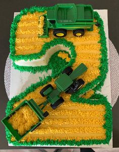 there is a cake that looks like a farm scene with tractors and corn on it