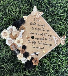 a graduation cap with flowers on it sitting in the middle of some green grass and there is a message that says, i was belk enough to listen to my heart and story