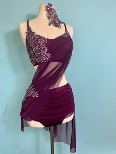 a mannequin wearing a purple dress with sequins on the neckline