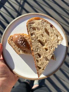 a person holding a plate with two pieces of bread on it