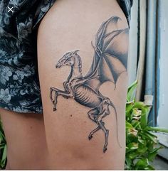 a black and white photo of a dragon on the back of a woman's arm