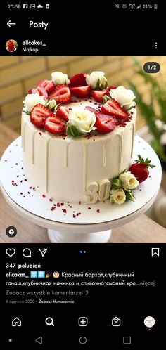 the cake is decorated with strawberries and roses on it's side, along with white icing