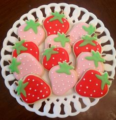 decorated cookies in the shape of strawberries on a plate