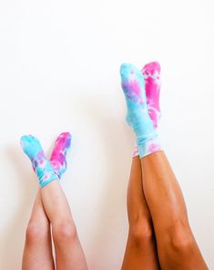 two legs with blue and pink tie - dyed socks laying on top of each other