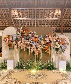 an arrangement of flowers is displayed on the wall in front of a large area rug