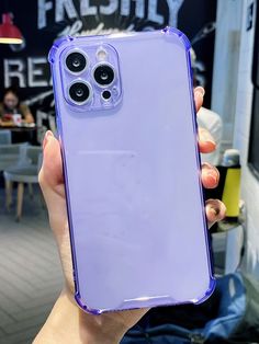 a person holding up a purple phone case