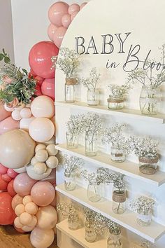 there is a display with balloons and flowers on the shelves for baby in bloom's