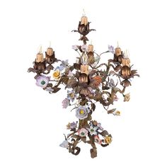 a chandelier with many candles and flowers on it