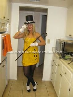 a woman in a yellow dress and top hat is cleaning the kitchen