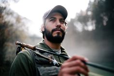 a man with a beard holding a fishing rod