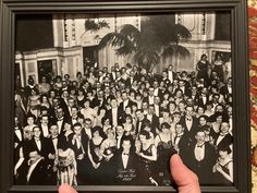 a black and white photo of a group of people in formal wear posing for the camera