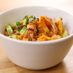 a white bowl filled with food on top of a wooden table