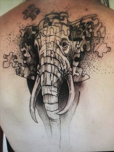 an elephant tattoo on the back of a woman's upper body, with black and grey ink