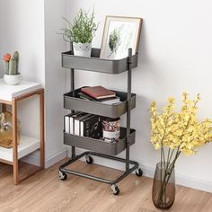 a shelf with books and plants on it in the corner next to a vase filled with flowers