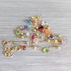 This dainty Necklace features  beautiful tiny   briolette  shaped  Tourmaline gemstones , and many other gemstone in roundel cut : Peridot , Amethyst ,Garnet , Citrine, Carnelian, Apatite and  Iolite gemstones A riot of dainty colorful , gemstone in a minimalist style The genuine gemstones  and gold filled ball spacers are handwrapped on a gold filled dainty chain. This colorful, precious jewel  finishes  with a gold filled spring ring clasp The briolette gemstone are of very good quality and they measure  5-6 mm the roundels are 3-4 mm please refer to measurement The necklace closes at 43 cm - 16.92 nches and I  added  an  extender chain at the clasp (3 cm) Please note that  you will receive the exact necklace shown in the photos above http://www.etsy.com/shop/lisacreazioni Gold Rondelle Natural Stones Gemstones, Gold Rondelle Crystal Necklace With Gemstone, Gold Briolette Crystal Necklaces With Natural Stones, Dainty Briolette Faceted Crystal Necklaces, Dainty Faceted Briolette Crystal Necklace, Dainty Briolette Faceted Crystal Necklace, Gold Filled Necklace, Dainty Chain, Precious Jewels