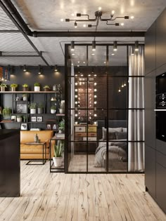 an industrial style living room with wood floors and glass doors that lead into the bedroom