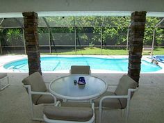 a table and chairs in front of a swimming pool