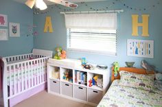 a baby's room with blue walls and white furniture