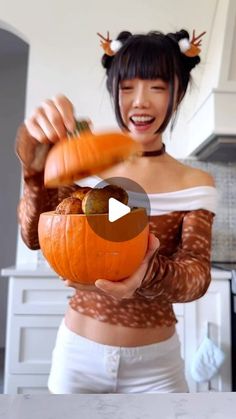 a woman holding a pumpkin in her hands