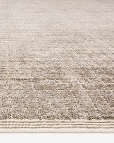 an area rug with squares and lines on the bottom in neutral colors, including beige