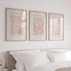 two framed pictures hang above a bed in a bedroom with white linens and pillows